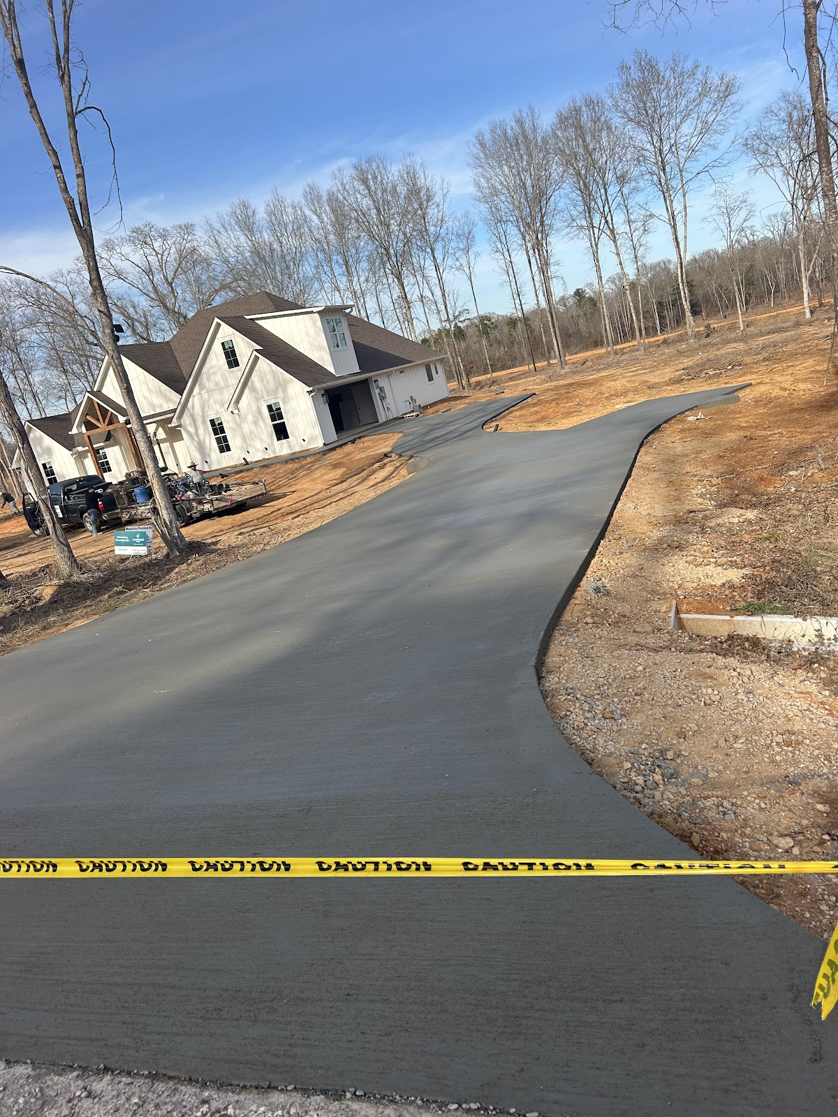 Long new concrete driveway poured by HBR Concrete leading up to a new build home