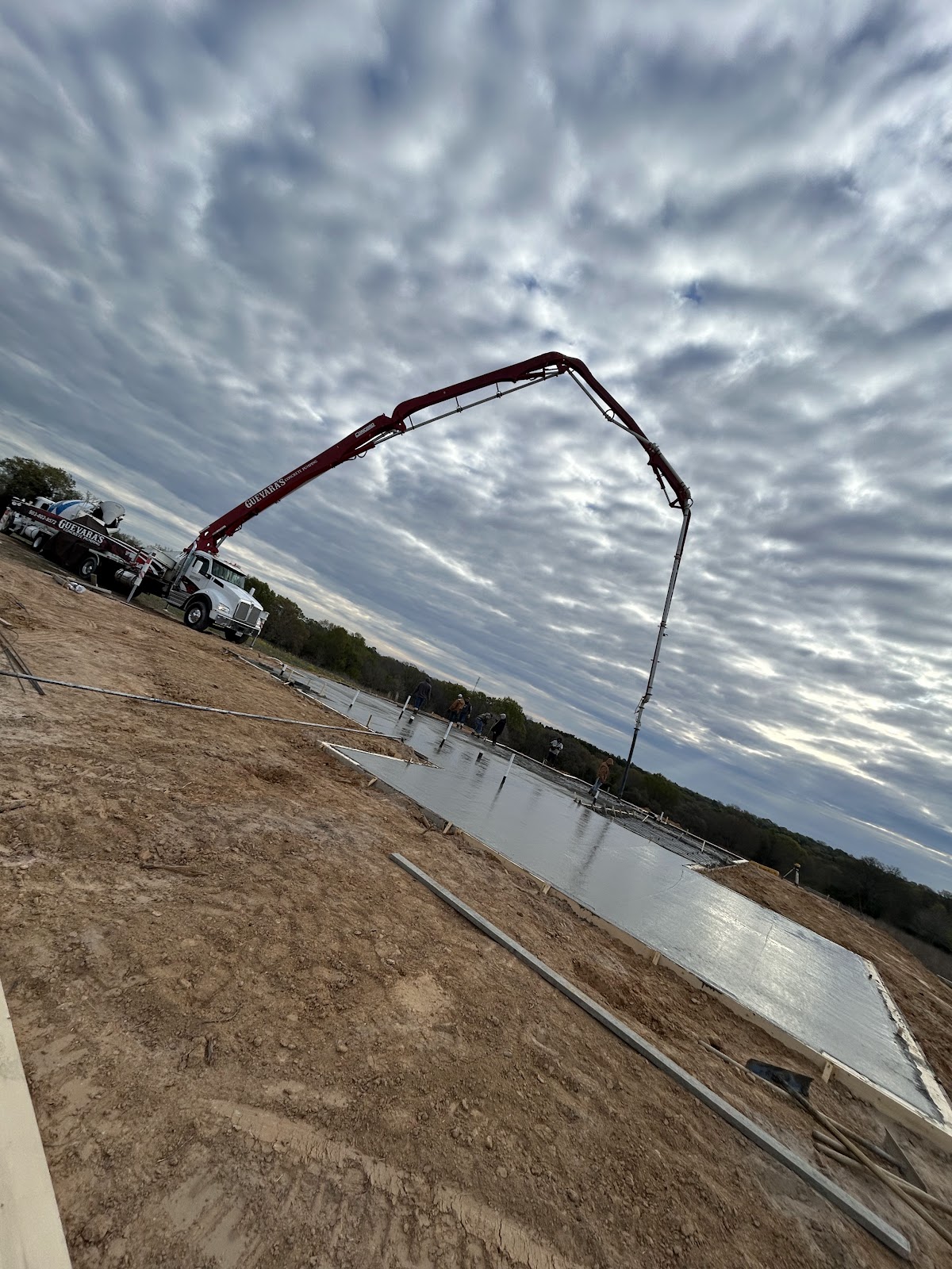 Concrete pump truck boom extended over a slab pour